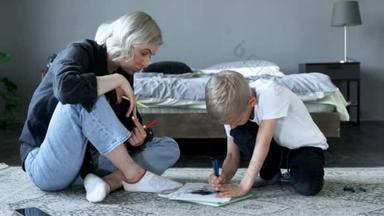 妈妈观看并指导孩子在纸上用彩笔画画